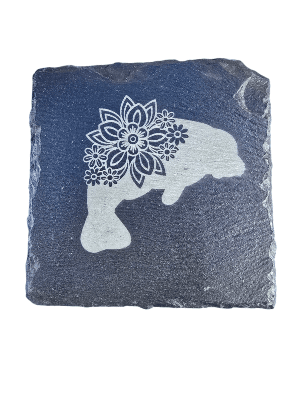 Laser-engraved manatee with floral detail on square slate coaster