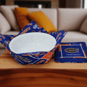 Handmade bowl cozy and matching coaster in Florida Gators fabric displayed on coffee table