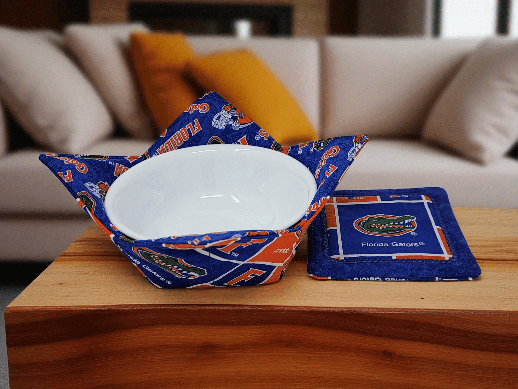 Handmade bowl cozy and matching coaster in Florida Gators fabric displayed on coffee table